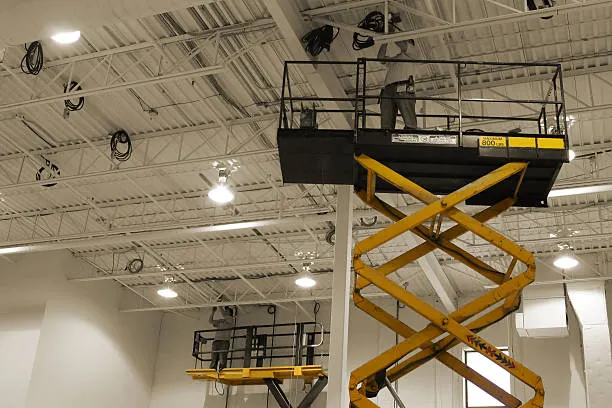 KappaOne electrician on a scissor lift installing conduit and lighting in a commercial ceiling